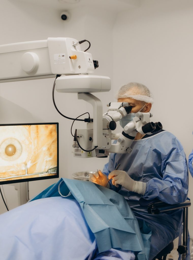 Skilled surgeon and his medical team performs precise eye surgery on an elderly patient, restoring